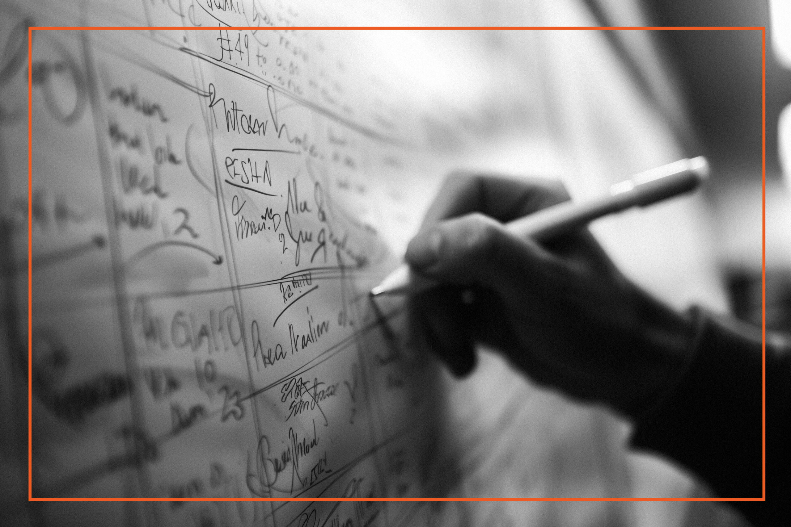 A hand writing on a whiteboard filled with notes and signatures, representing planning and organization in the context of cultural change, leadership, and execution.